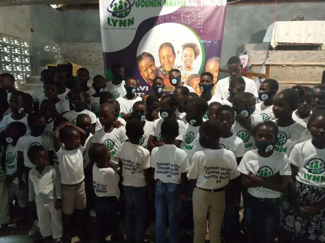 Children in LYNN t-shirts at a community event in Haiti